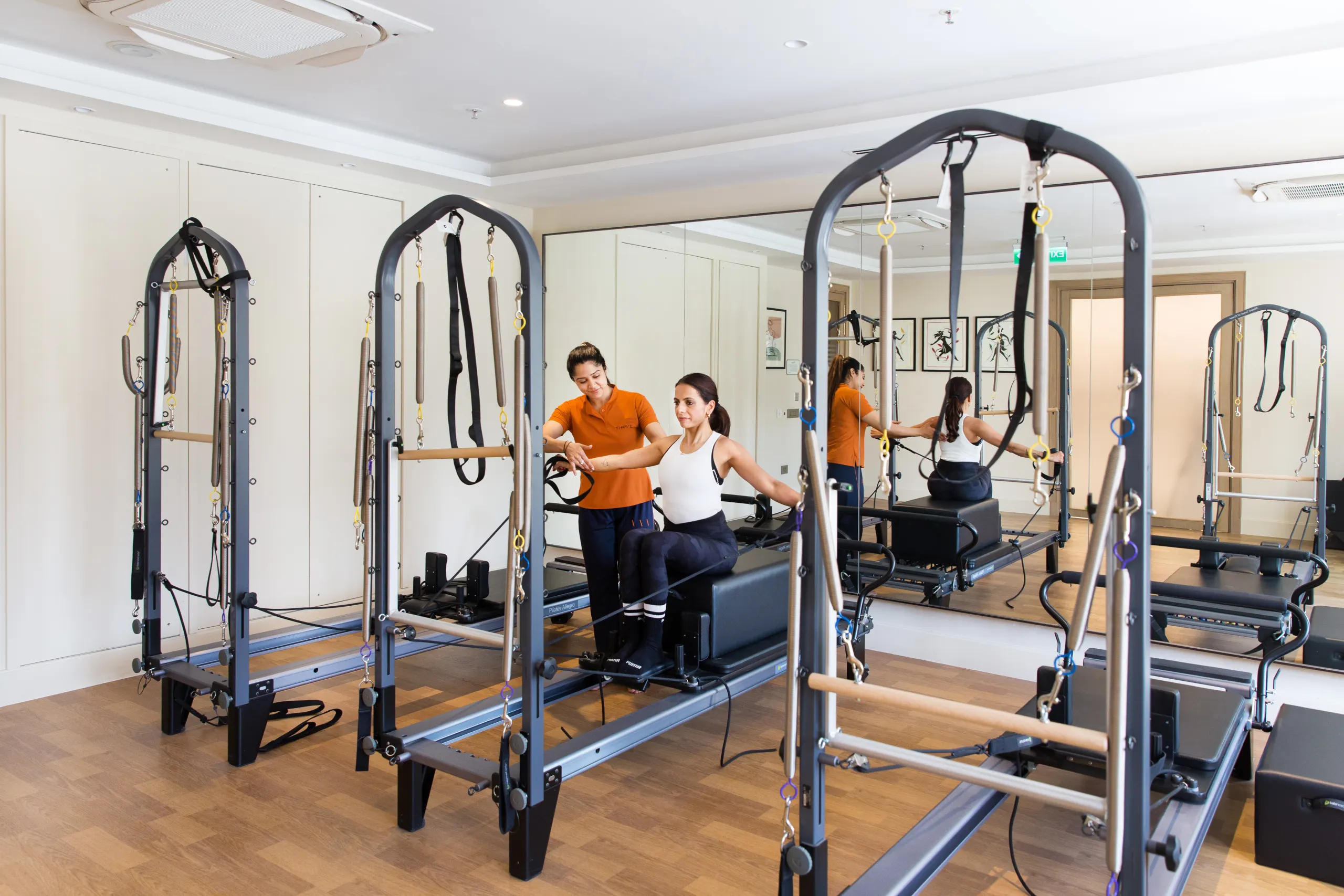 Instructor guiding a Pilates reformer session at DLF THRIVE Club 4